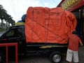 A man is putting a safety rope on a truck carrying groceries in the city of Malang