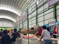 bustling atmosphere inside a traditional market with shoppers at the stalls