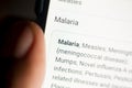 Malaria News on the phone.Mobile phone in hands. selective focus and chromatic aberration effects