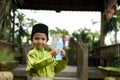 A Malay boy in Malay traditional cloth showing his happy reaction after received money pocket during Eid Fitri or Hari Raya celebr Royalty Free Stock Photo