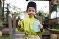 A Malay boy in Malay traditional cloth showing his happy reaction after received money pocket during Eid Fitri or Hari Raya celebr Royalty Free Stock Photo