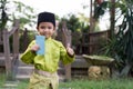 A Malay boy in Malay traditional cloth showing his happy reaction after received money pocket during Eid Fitri or Hari Raya celebr Royalty Free Stock Photo