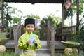 A Malay boy in Malay traditional cloth showing his happy reaction after received money pocket during Eid Fitri or Hari Raya celebr Royalty Free Stock Photo