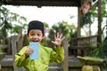 A Malay boy in Malay traditional cloth showing his happy reaction after received money pocket during Eid Fitri or Hari Raya celebr