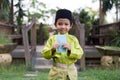 A Malay boy in Malay traditional cloth showing his happy reaction after received money pocket during Eid Fitri or Hari Raya celebr Royalty Free Stock Photo