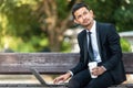 Malay Business man working on his laptop during his coffee break at the park