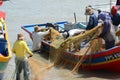 Malay fishermen cleaning a net