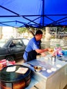 Malay man making a different type of roti canai fried on big pan