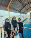 Malay mother with children at the colourful bridge near the river. Single parent