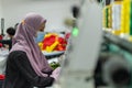 Malay Muslim Female Worker with protective face mask and maintaining social distancing while working in Embroidery Textile Garment