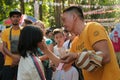 Malaybalay City, Philippines - male artist paints cheek of young girl at the Kaamulan Festival in Bukidnon. Event facepaint.