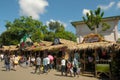 Malaybalay City, Philippines - people walk on busy street with decorated nipa huts as pop-up stores at the Kaamulan Festival.