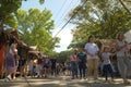 Malaybalay City, Philippines - people walk past a busy street with nipa huts for pop-up local stores at Kaamulan Festival.