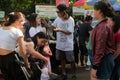 Malaybalay City, Philippines - woman gets face painted by male artist at Kaamulan Festival in Bukidnon. Crowd watches.