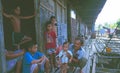 Borneo: Iban Headhunter with kids playing and sitting in front of the long house in the rain forest of Sarawak