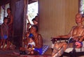 Borneo: Older Iban Headhunter sitting in a typical long house with lot`s of kids around