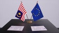 Malaysia and EU flag on table. Politics deal or business agreement with country 3D illustration