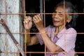 Portrait of an indigenous village woman looking from the window of wooden house