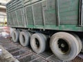 Eight tires on the side of a trailer truck carrying kernal seeds.