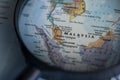 Malaysia on a world map through magnifying glass.