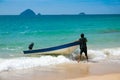 Malaysian beach and man struggling with his boat Royalty Free Stock Photo