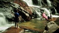 Malaysian family lays at the bottom of a waterfall to cool off heat