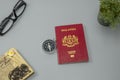 Malaysian red passport with compass, spectacles notebook and green plant