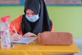 Malaysian students wear face shields and facemasks in classroomfor protect from Covid -19. New normal education