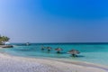 Maldives, Feb 3rd 2018 - Beach umbrellas at the shallow blue water with some divers enjoying the tropical weather of Maldives Royalty Free Stock Photo