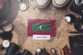 Maldives Flag Between Traveler`s Accessories on Old Vintage Map. Overhead Shot