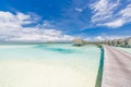 Maldives island, luxury water villas resort and wooden pier jetty. Beautiful sky and ocean lagoon beach. Summer scenic Royalty Free Stock Photo