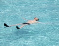 Maldives. Teenager has a rest on turquoise transparent water of ocean