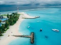 Maldives tropical beach with pier and boats in blue ocean. Travel vacation concept. Aerial view Royalty Free Stock Photo