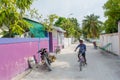 Maldivian boy riding bicycle on the street in the village at the tropical island Royalty Free Stock Photo