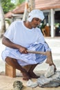 Maldivian construction worker in traditional national maldivian clothes cracking coral rocks with the axe Royalty Free Stock Photo