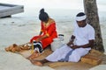 Maldivian couple dressed in national clothes cooking food
