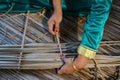 Maldivian girl stitches dry palm leaves using big needle Royalty Free Stock Photo