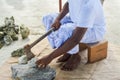 Maldivian man in national clothes cracks the coral rocks using axe Royalty Free Stock Photo