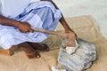 Maldivian man national clothes cracks the dead coral rocks using axe Royalty Free Stock Photo