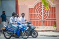 Maldivian men wearing masks while driving motorbikes on the street during covid-19