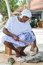 Maldivian muslim construction worker in traditional national maldivian clothes smashing coral rocks with the axe