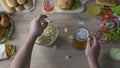 Male abusing harmful food, eating full arms of popcorn and drinking lots of beer