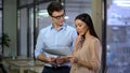 Male accountant discussing costs with female director of company showing papers