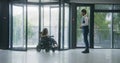 Male administrator meets woman in wheelchair in clinic Royalty Free Stock Photo