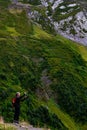 Male adult exploring the outdoors, taking a photo of a breathtaking mountain range