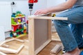 A male adult person assembling from flat-pack a set of two small chairs with desk. Royalty Free Stock Photo