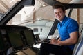 Portrait Of Male Aero Engineer With Clipboard Working In Helicopter Cockpit Royalty Free Stock Photo