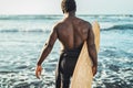 Male afro surfer having fun surfing during sunset time - African man enjoying surf day Royalty Free Stock Photo