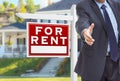 Male Agent Reaching for Hand Shake in Front of For Rent Sign