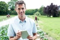 Male Agricultural Worker Using Digital Tablet In Field